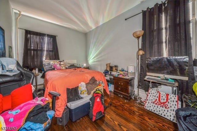 bedroom with dark hardwood / wood-style flooring