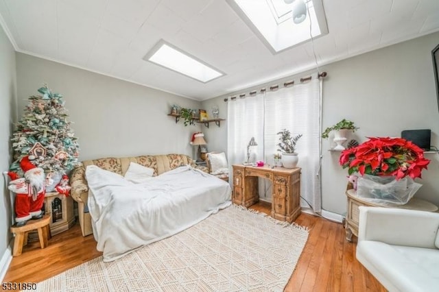 bedroom with hardwood / wood-style floors and a skylight