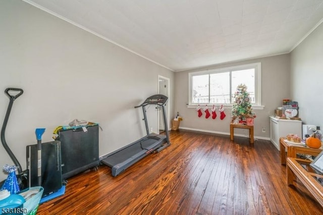 workout area with crown molding and dark wood-type flooring