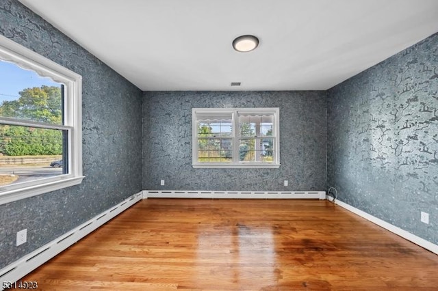 unfurnished room featuring a baseboard radiator and wood-type flooring