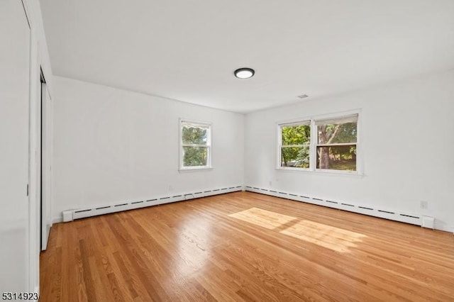 spare room with a baseboard radiator and hardwood / wood-style floors