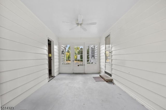 unfurnished sunroom with ceiling fan