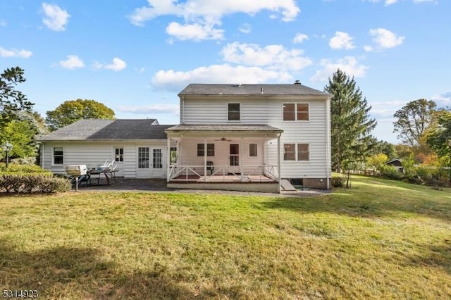 rear view of property featuring a patio area, a deck, and a lawn