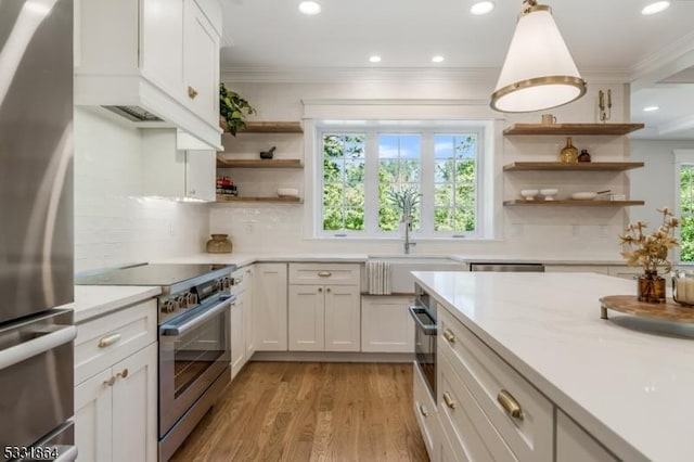 kitchen with white cabinetry, appliances with stainless steel finishes, tasteful backsplash, and hanging light fixtures