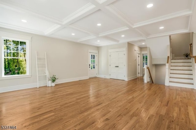 unfurnished living room featuring beam ceiling, coffered ceiling, and light hardwood / wood-style floors