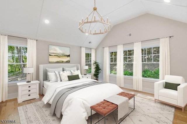 bedroom with vaulted ceiling, a chandelier, light hardwood / wood-style flooring, and multiple windows