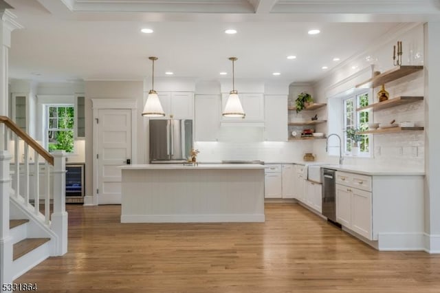 kitchen featuring decorative light fixtures, white cabinets, decorative backsplash, and stainless steel appliances