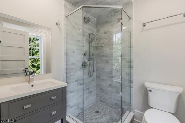 bathroom with toilet, vanity, and walk in shower