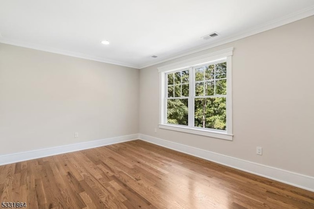 spare room featuring crown molding and hardwood / wood-style flooring