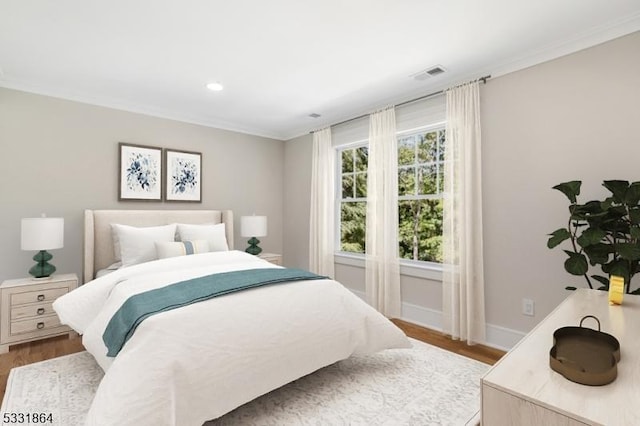 bedroom with wood-type flooring and crown molding