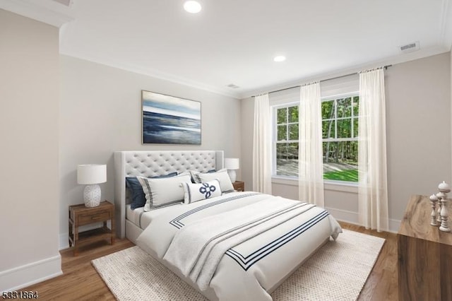 bedroom with wood-type flooring and crown molding