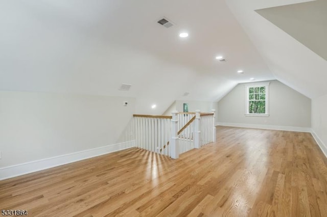 bonus room featuring lofted ceiling and light hardwood / wood-style flooring