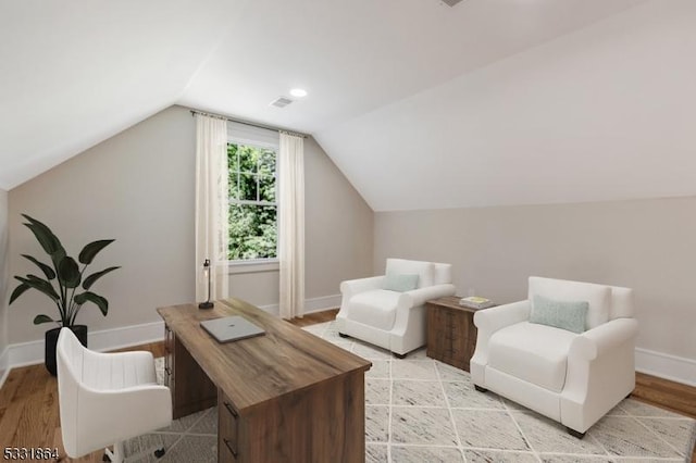 home office with light hardwood / wood-style floors and vaulted ceiling