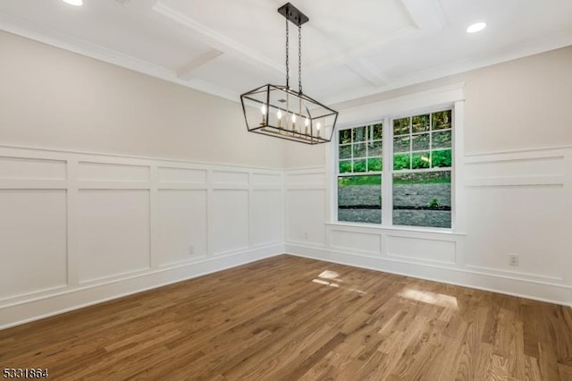 unfurnished dining area with coffered ceiling, a chandelier, and wood-type flooring