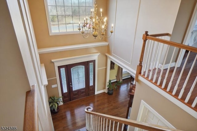 foyer with dark hardwood / wood-style floors and a notable chandelier