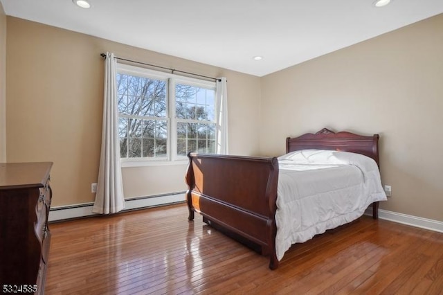 bedroom with hardwood / wood-style flooring and baseboard heating