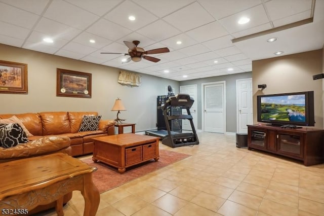 living room with a paneled ceiling, ceiling fan, and light tile patterned floors