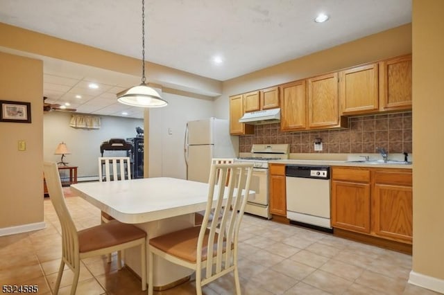 kitchen with tasteful backsplash, sink, hanging light fixtures, and white appliances