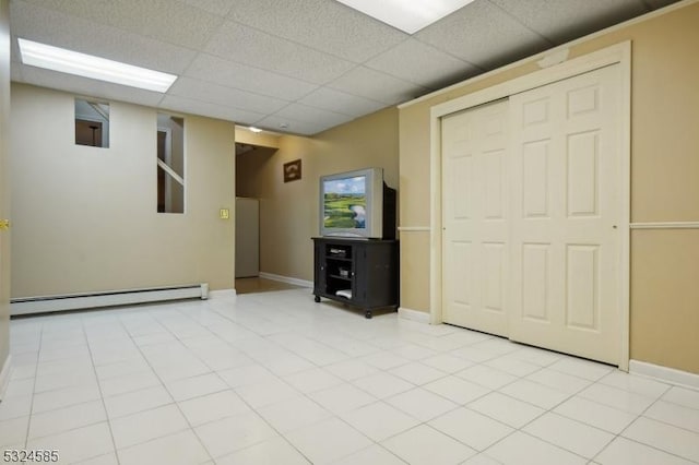 interior space with a paneled ceiling and a baseboard heating unit