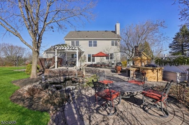 back of house featuring a pergola, area for grilling, exterior bar, a patio, and a lawn