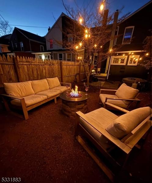 view of patio / terrace with an outdoor living space with a fire pit and fence