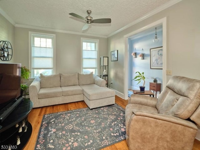 living room featuring wood finished floors, baseboards, ceiling fan, ornamental molding, and a textured ceiling