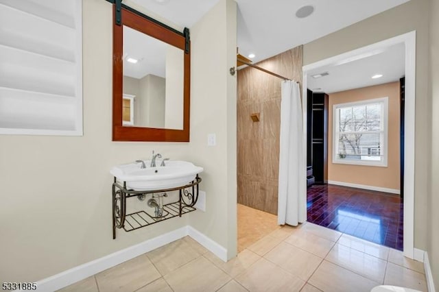 bathroom with a shower with curtain and tile patterned flooring