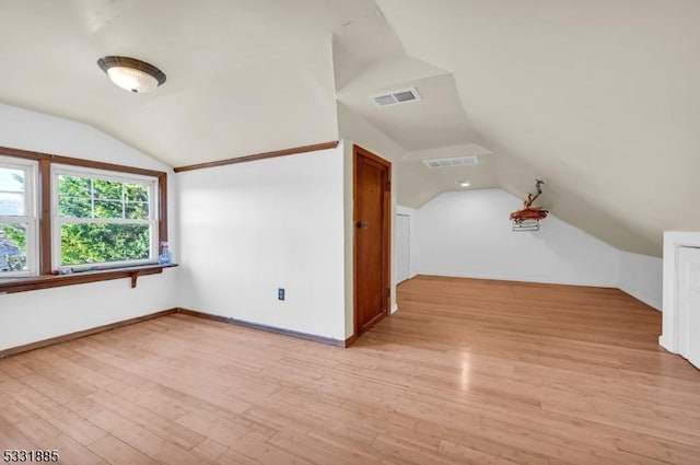 additional living space with light wood-type flooring and lofted ceiling