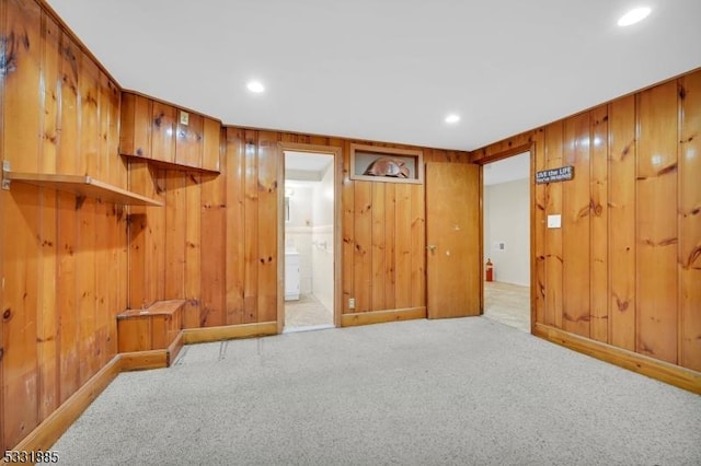 carpeted spare room with wood walls