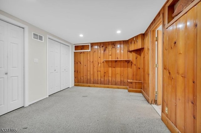 interior space with wood walls and light colored carpet