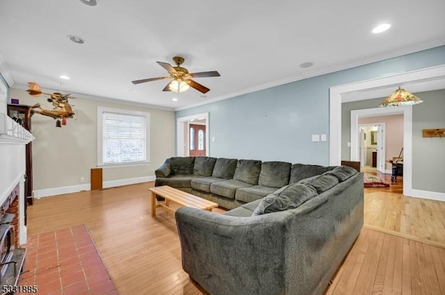 living room with hardwood / wood-style flooring, a brick fireplace, ceiling fan, and ornamental molding