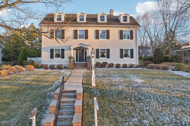 colonial home with central air condition unit and a front lawn