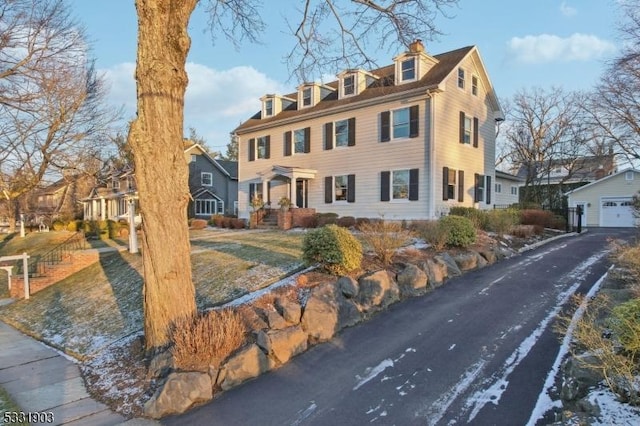 view of front of home with a garage and an outdoor structure