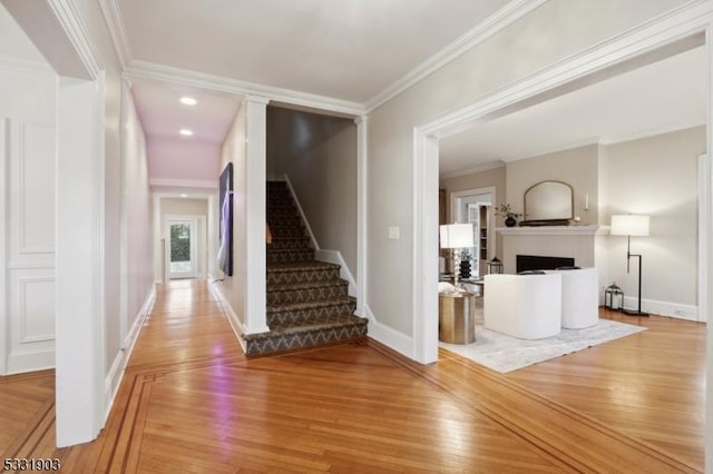 foyer entrance with hardwood / wood-style floors and crown molding