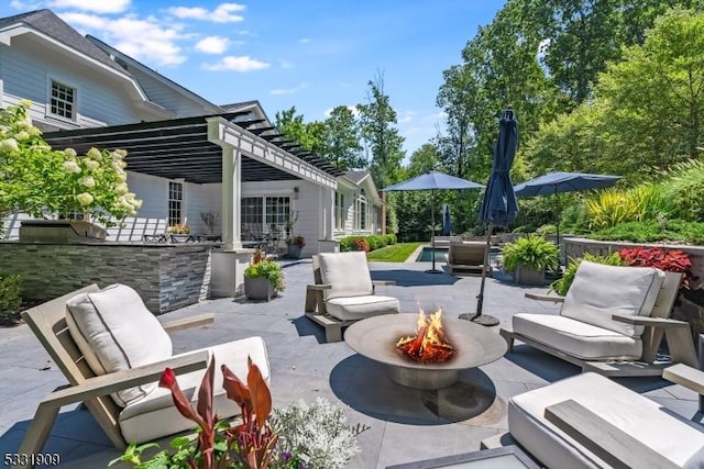 view of patio / terrace featuring a pergola and an outdoor living space with a fire pit