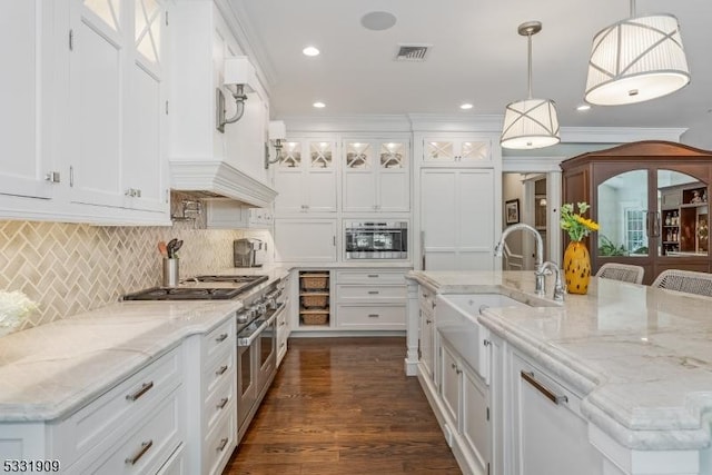 kitchen with sink, stainless steel appliances, backsplash, decorative light fixtures, and white cabinets