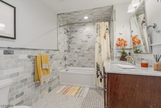 full bathroom featuring vanity, tile patterned floors, toilet, tile walls, and shower / tub combo