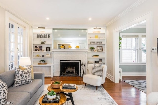 living room featuring french doors, a fireplace, hardwood / wood-style flooring, and crown molding