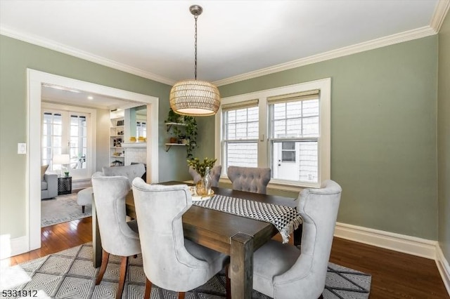 dining room with hardwood / wood-style flooring and crown molding