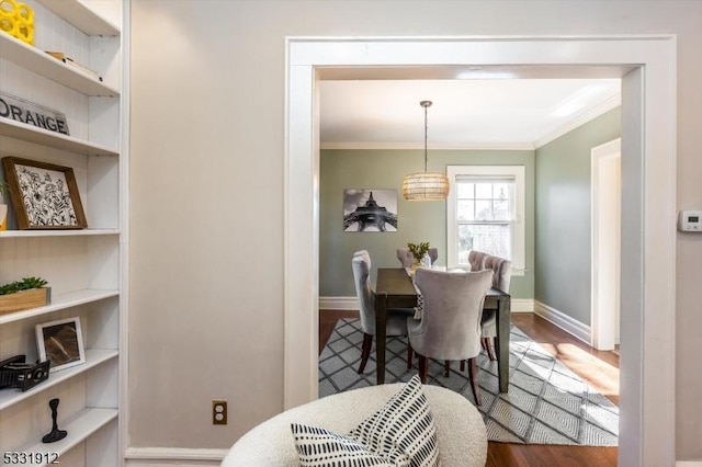 dining room featuring hardwood / wood-style flooring, ornamental molding, and a chandelier