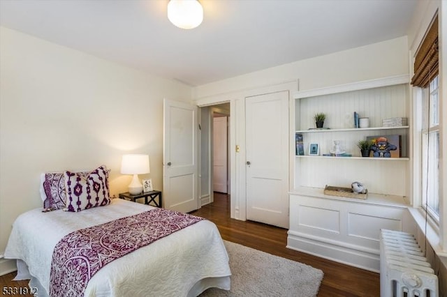 bedroom featuring dark wood-type flooring and radiator heating unit