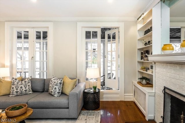 living room featuring crown molding, french doors, dark hardwood / wood-style floors, and a fireplace