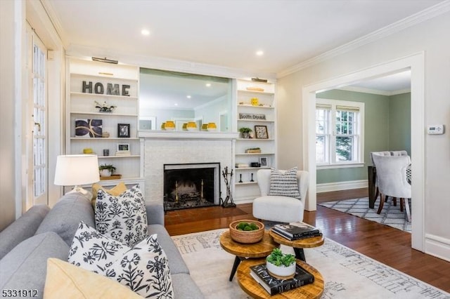 living room with a brick fireplace, ornamental molding, and wood-type flooring