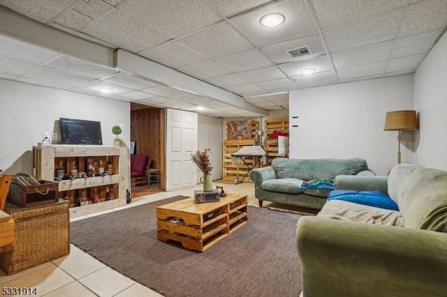 tiled living room featuring a paneled ceiling