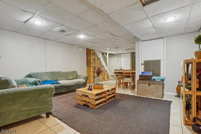 tiled living room with a paneled ceiling