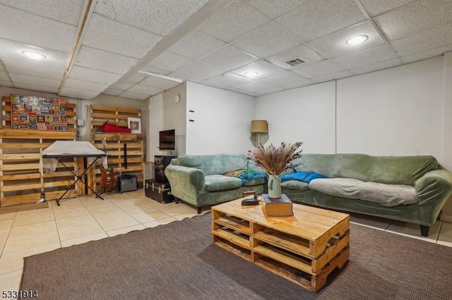 living room with a drop ceiling and tile patterned floors