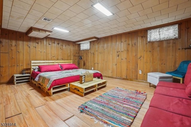 bedroom featuring wood walls and hardwood / wood-style floors