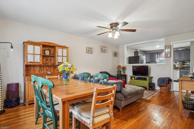 dining space with ceiling fan and hardwood / wood-style flooring