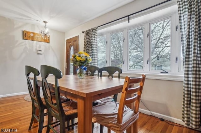 dining area with plenty of natural light, a notable chandelier, and light hardwood / wood-style floors