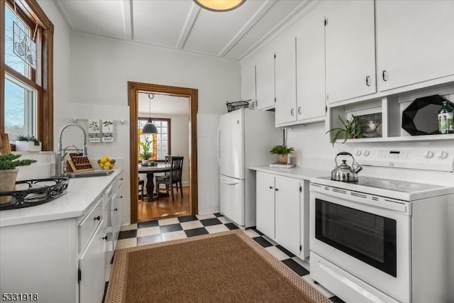 kitchen with white cabinets, white appliances, hanging light fixtures, and sink